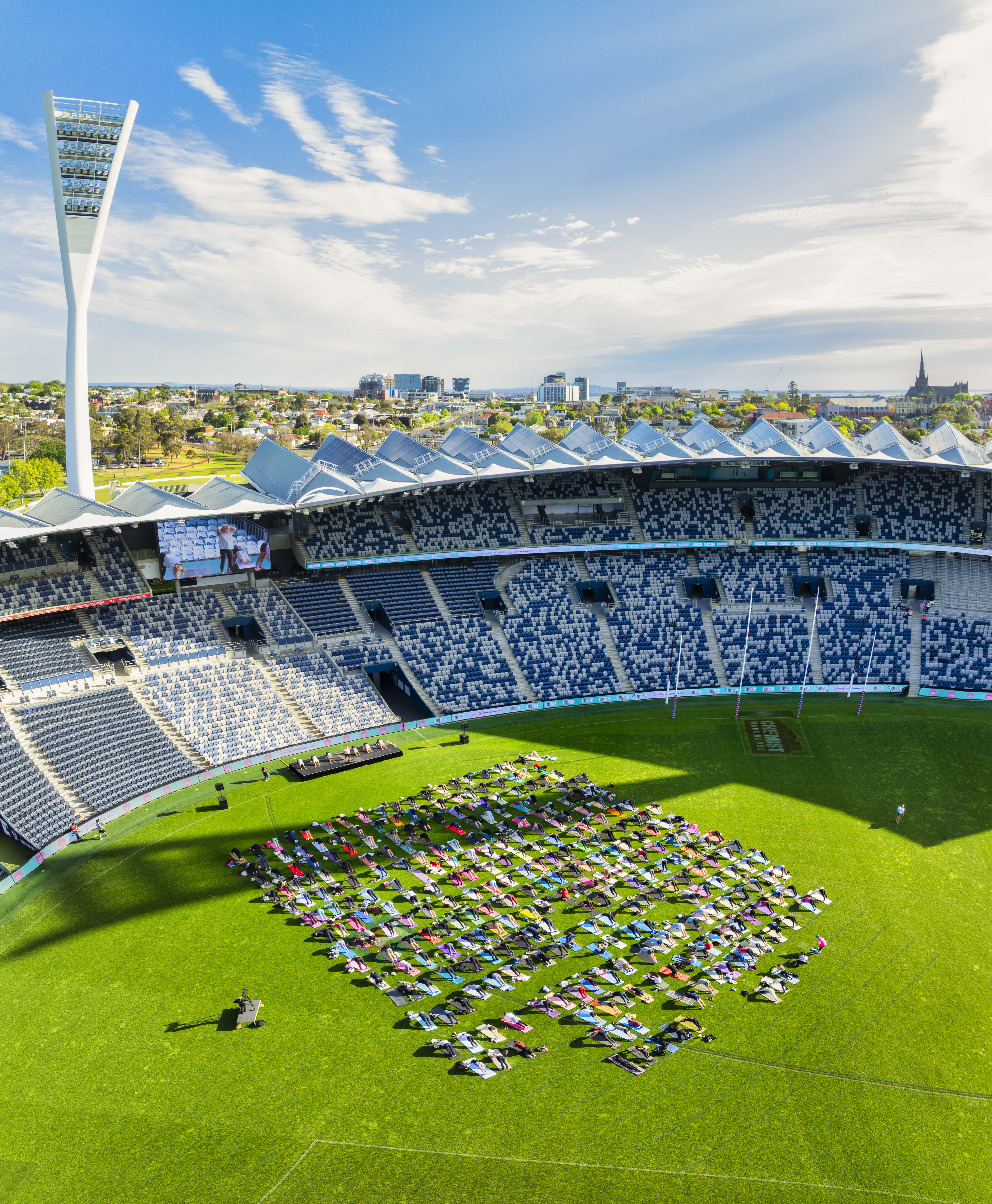 Hundreds of people on their mats across the oval at GMHBA Stadium